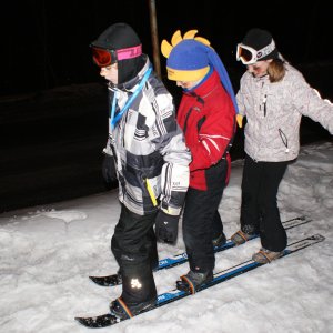 Uczestnicy obozu zimowego w trakcie zabawy z mega nartami.